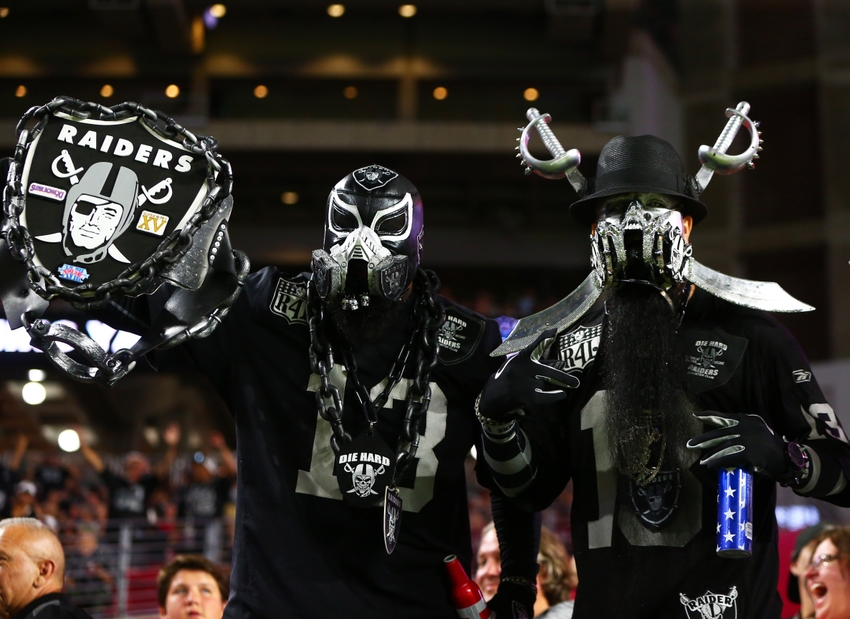 Oakland Raiders fans wear costumes in the crowd against the Arizona Cardinals during a preseason game at University of Phoenix Stadium