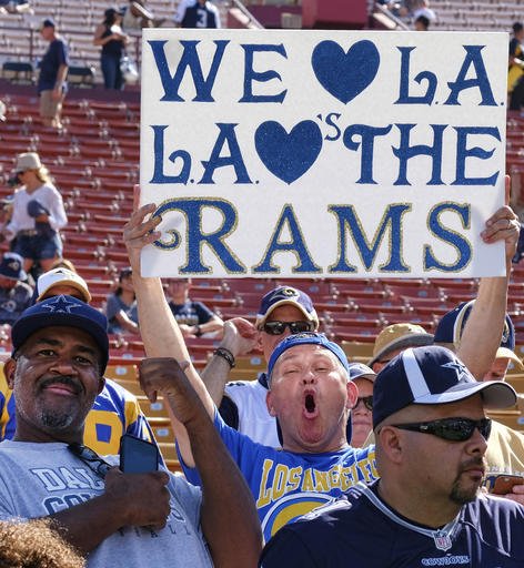 A Los Angeles Rams fan displays a sign while waiting for his team to arrive at Los Angeles Memorial Coliseum on Saturday Aug. 13 2016. Los Angeles fans celebrate the return of the NFL and their long-lost Los Angeles Rams to the city at the team's first