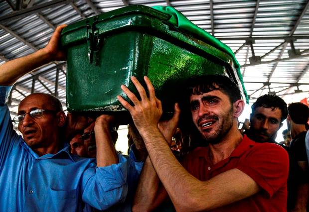 Relatives carry a victim’s coffin to the local cemetery