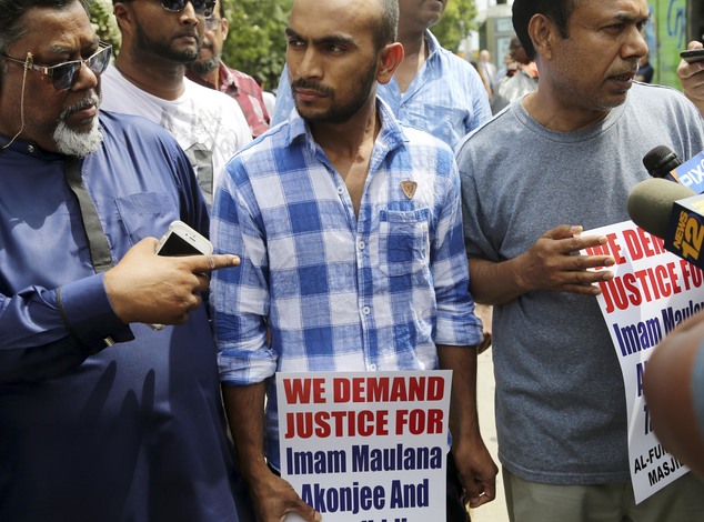 Saif Akonjee son of Imam Maulana Alauddin Akonjee center Mashuk Uddin brother of Thara Uddin right and other members of the community are surrounded