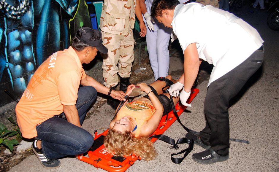 Rescue workers help an unidentified woman after a bomb blast in the southern resort city of Hua Hin. Pic AP