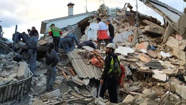 Rescuers search for survivors at a collapsed house after a powerful earthquake hit central Italy