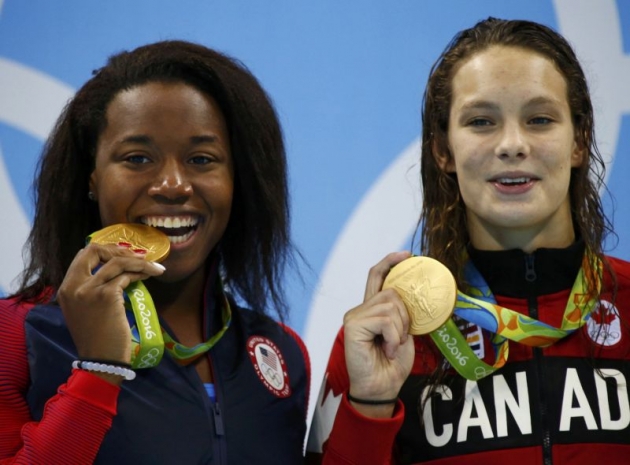 Simone Manuel left celebrates after receiving her gold medal