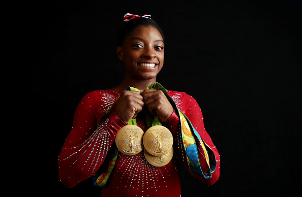 Portrait of Team USA gymnast Simone Biles posing with 4 Gold medals and 1 Bronze medal during