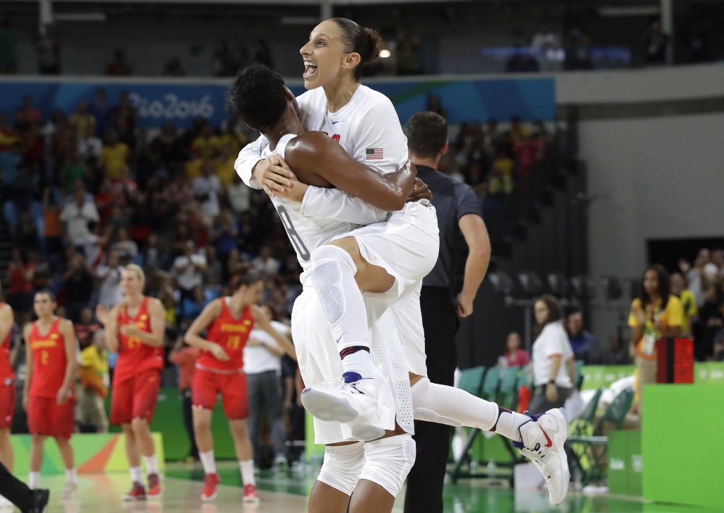 U.S. basketball player Diana Taurasi, leaps into the arms of teammate Angel Mc Coughtry as they celebrate their 101-72 win over Spain in the gold medal game on Saturday