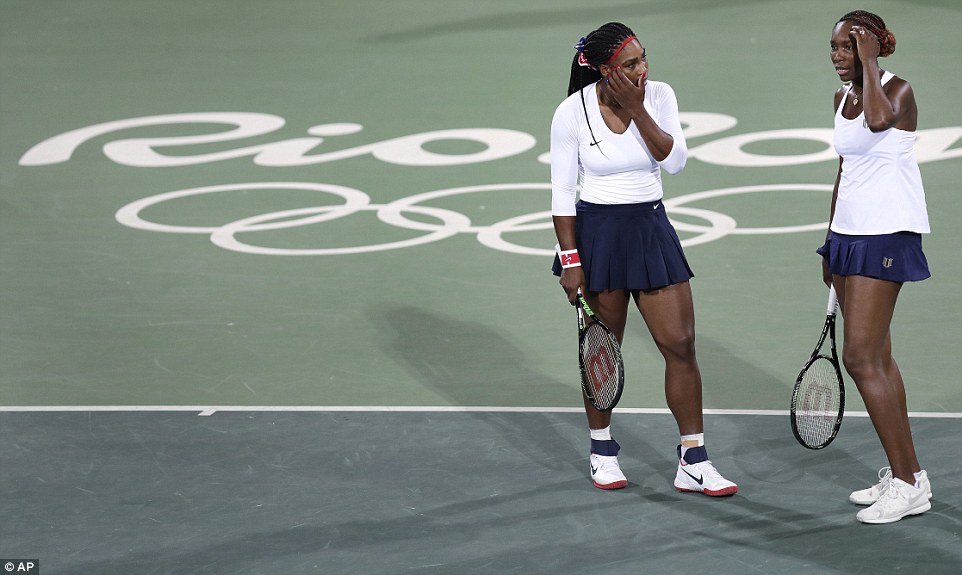 Venus Williams of the United States right talks with her sister Serena after losing a point in a doubles match against Lucie Sarfarova and Barbora Strycova