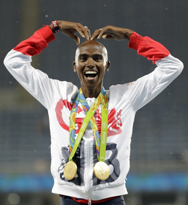 Mo Farah does the'Mo-bot with two gold medals around his neck