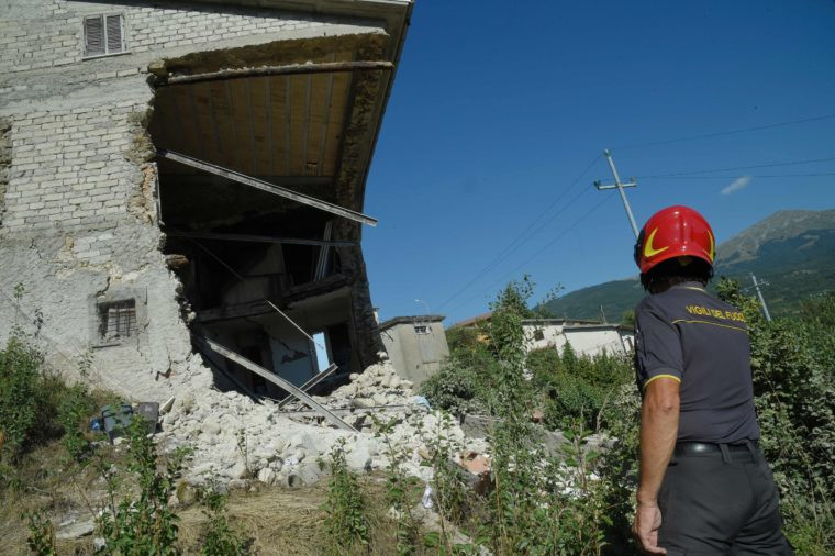 Firefighters visit damaged houses with residents to collect their belonging a few days after the earthquake hit