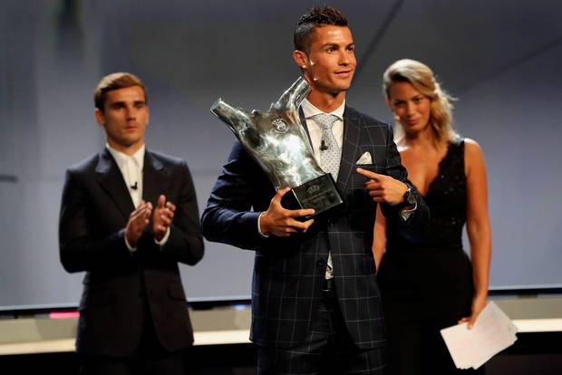 Real Madrid's Portuguese forward Cristiano Ronaldo poses with his trophy of Best Men's player in Europe next to Atletico Madrid's French forward Antoine Griezmann at the end of the UEFA Champions League Group stage draw ceremony