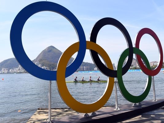 Rowers are seen through the Olympic rings as seen from Copacabana Beach on Aug. 6