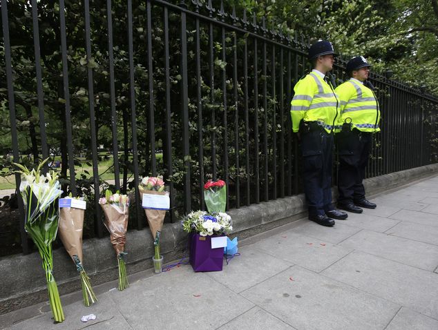 Floral tributes rest against railings Thursday Aug. 4 2016 near the scene of a fatal stabbing on Wednesday night in Russell Square London. London police