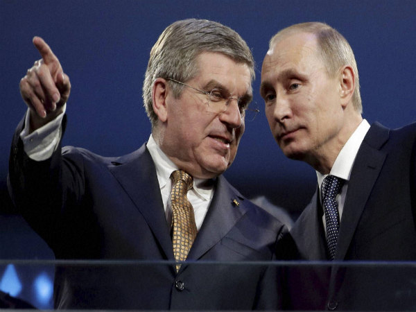 International Olympic Committee President Thomas Bach and Russian President Vladimir Putin watch the closing ceremony of the 2014 Winter Olympics in Russia