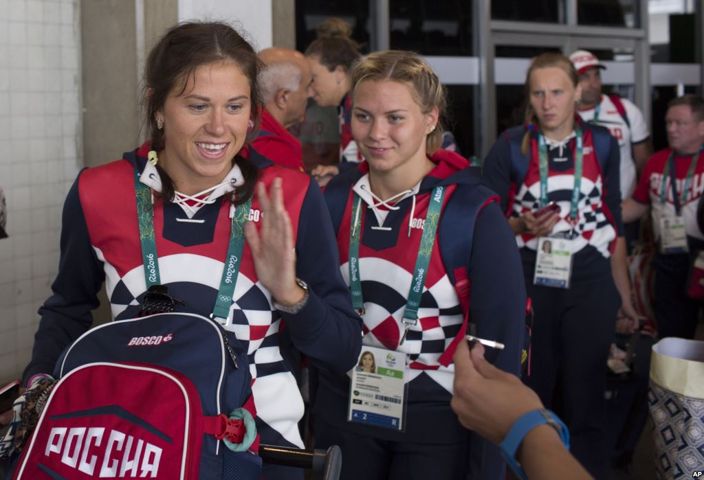 Members of the Russian Olympic delegation line up to board a bus after arriving at the Rio de Janeiro International Airport