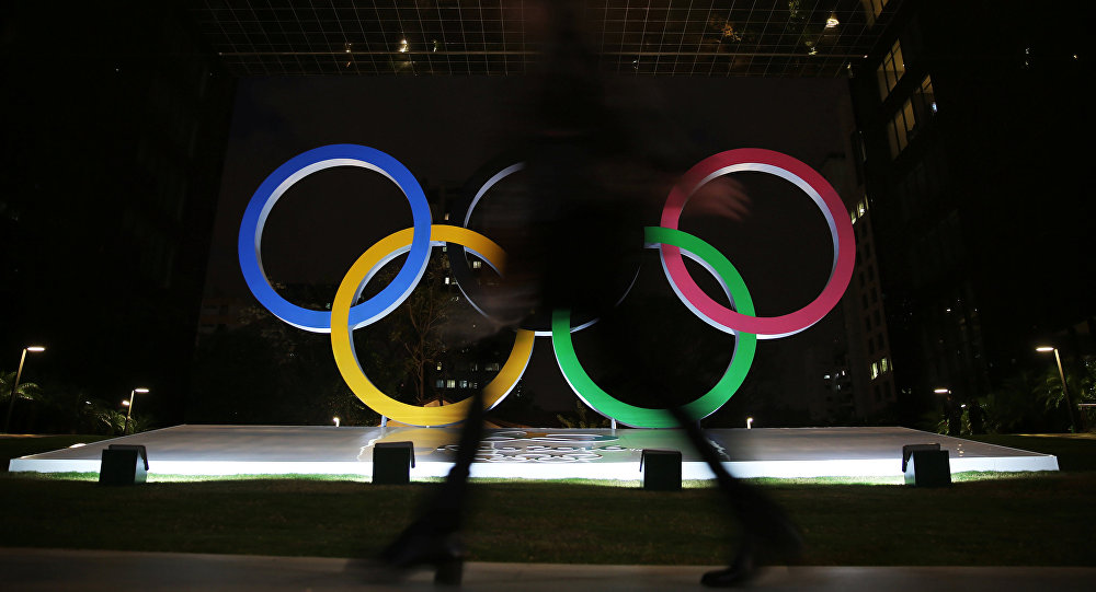 A woman walks past Olympic rings placed at the entrance of a office building ahead of the Rio 2016 Olympic Games in Sao Paulo Brazil