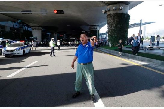 A South Korean war veteran shouts to oppose South Korean lawmakers's return from their visit to China at Incheon International Airport in Incheon South Korea Wednesday Aug. 10 2016. A group of lawmakers from the main opposition Minjoo Party of Korea