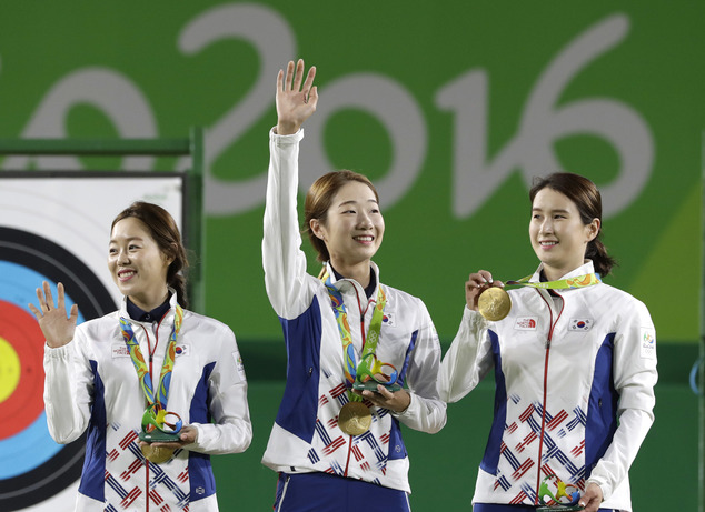 From left South Korea's Chang Hye-jin Choi Mi-sun and Ki Bo-bae celebrate their gold medals on the podium during the awards ceremony of the women's team