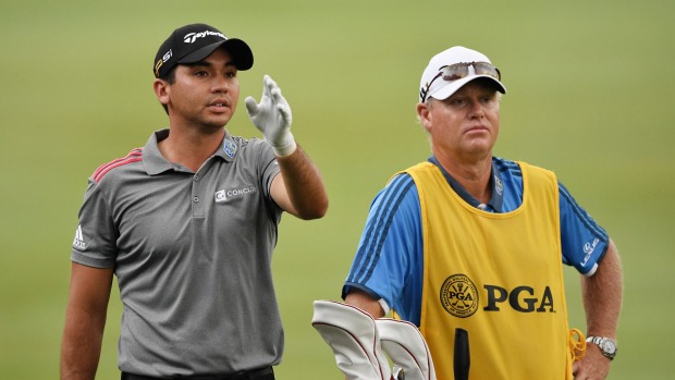 Day talks to his caddie Colin Swatton on the first hole during the continuation of the weather-delayed third round