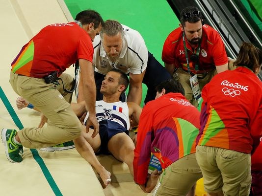 Samir Ait Said of France receives attention after falling while competing on the vault