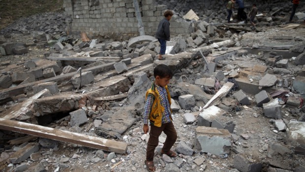 A boy walks on rubble of a house after it was destroyed by a Saudi-led air strike in Yemen's capital Sanaa