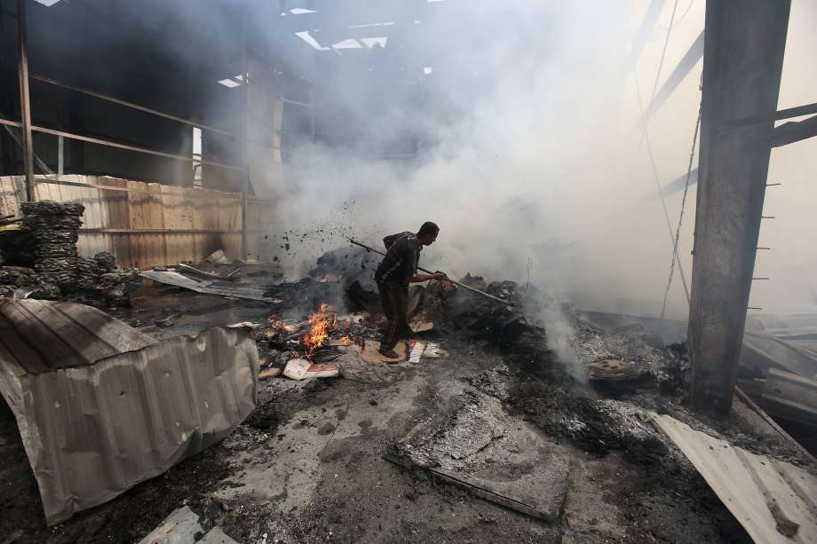 A man looks for survivors under the rubble of a food factory hit by Saudi-led air strikes in Sanaa Yemen