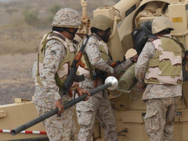 Saudi soldiers load an artillery piece at a position close to the Saudi Yemeni border