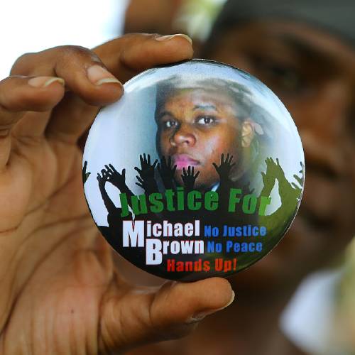 Nikki Jones of Spanish Lake Mo holds a button in support of Michael Brown while visiting the community in the apartment development near where he was fatally shot in Ferguson Mo. Brown's death'op