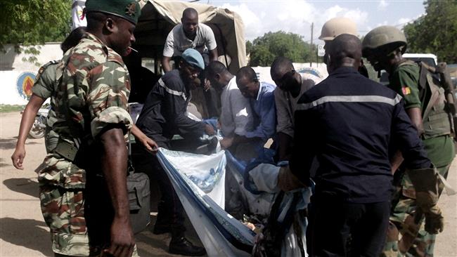 Security forces transport with a blanket the remains of victims of a double blast in the northern Cameroonian city of Maroua