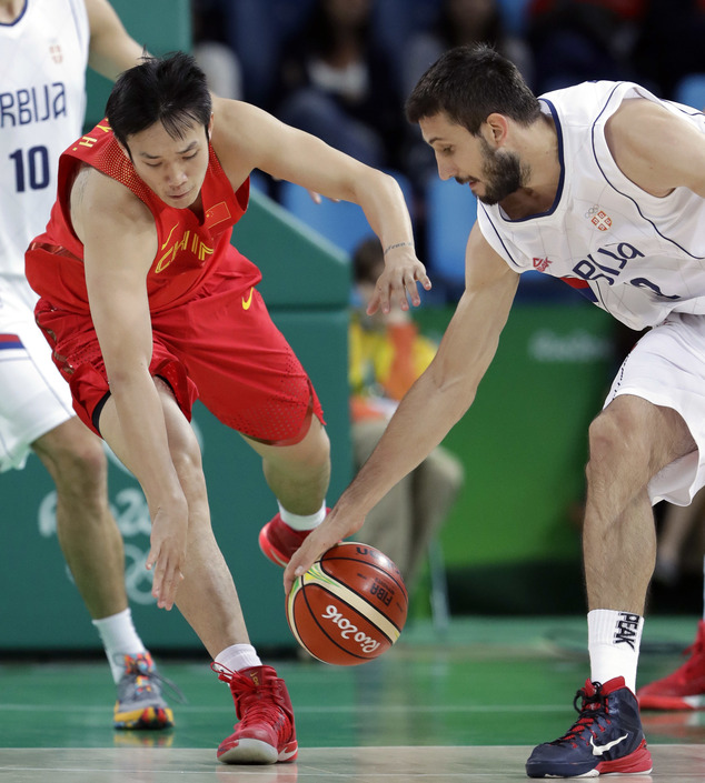 China's Ding Yanyuhang left and Serbia's Stefan Bircevic right chase a loose ball during a men's basketball game at the 2016 Summer Olympics in Rio de Ja