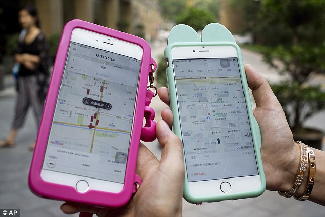 Similar Women hold smartphones showing the ride-hailing apps Uber left and Didi Chuxing right in Beijing