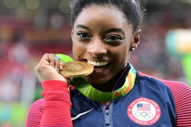 US gymnast Simone Biles celebrates with her gold medal after the women's individual all-around final in Rio