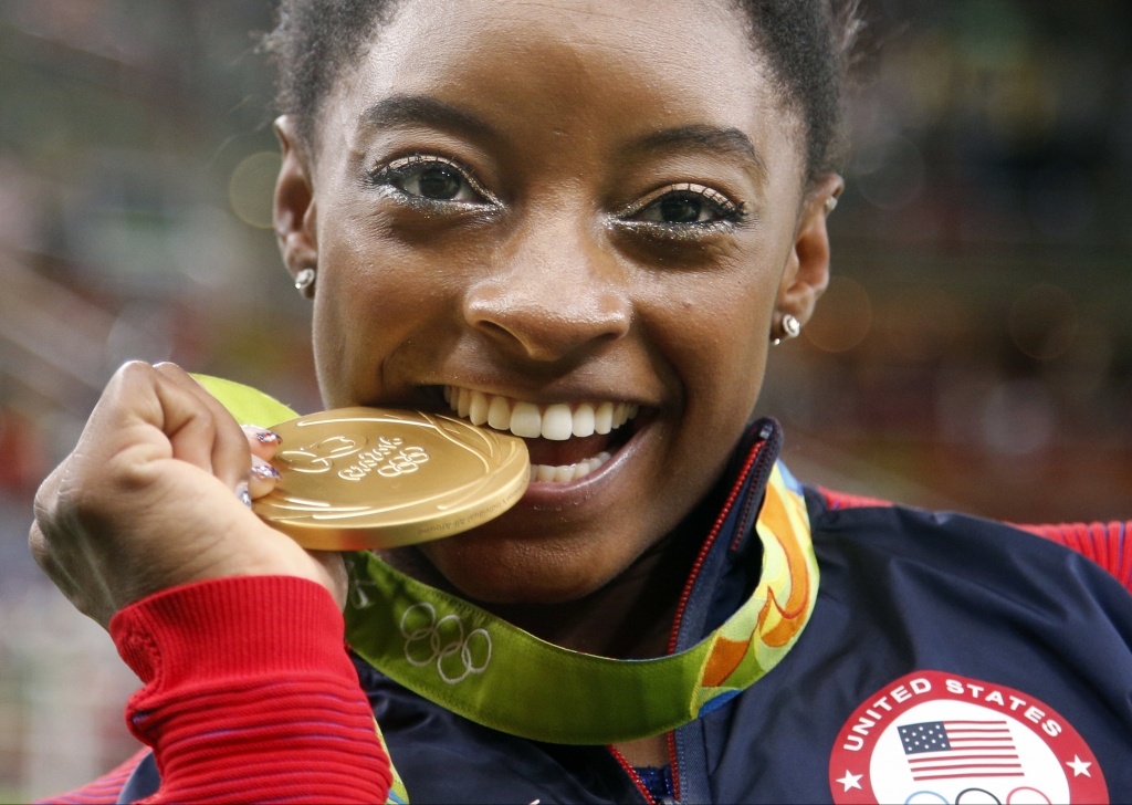 United States Simone Biles bites her gold medal for the artistic gymnastics women's individual all-around final at the 2016 Summer Olympics in Rio de Janeiro Brazil Thursday Aug. 11 2016