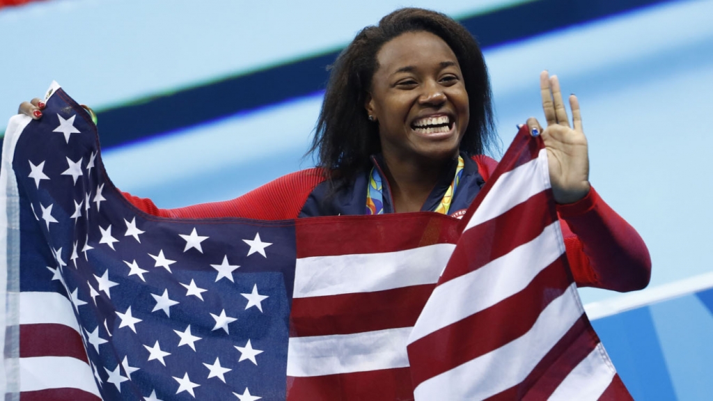 Simone Manuel waves the American flag after winning the gold medal in the 100-meter freestyle