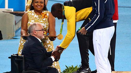 Sir Philip Craven, chairman of the International Paralympic Committee presents Usain Bolt with a gold medal for the 200m