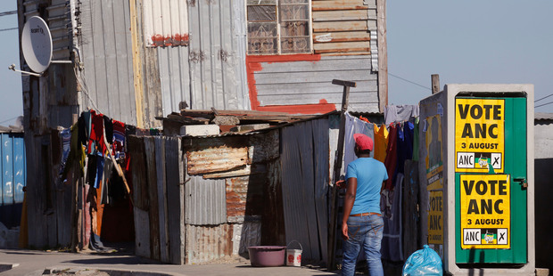 A man passes an African National Congress ANC political poster right in the township of Khayelitsha on the outskirts of Cape Town South Africa