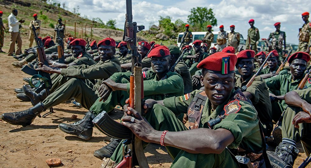 Sudan People's Liberation Army soldiers sit on the ground at a containment site outside of Juba