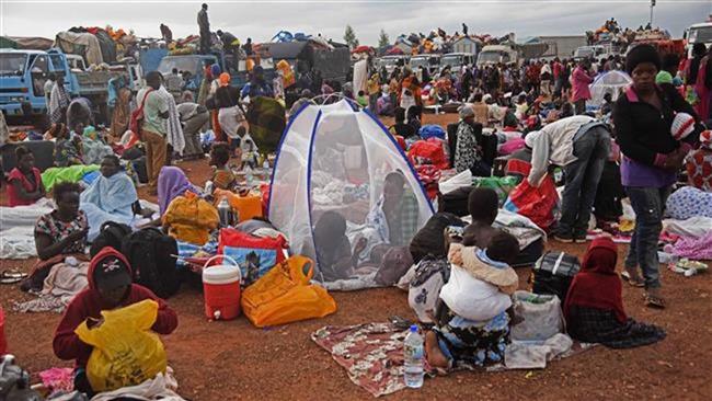 South Sudanese refugees gather inside a makeshift camp at Nimule border in Uganda