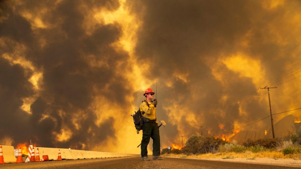 A firefighter radios that the Blue Cut fire is burning on both sides of Highway 138. So far more than 80,000 people have