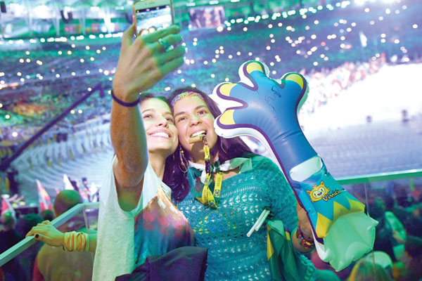 Spectators take a “selfie” during the closing ceremony of the Rio 2016 Olympic Games at the Maracana stadium on Sunday