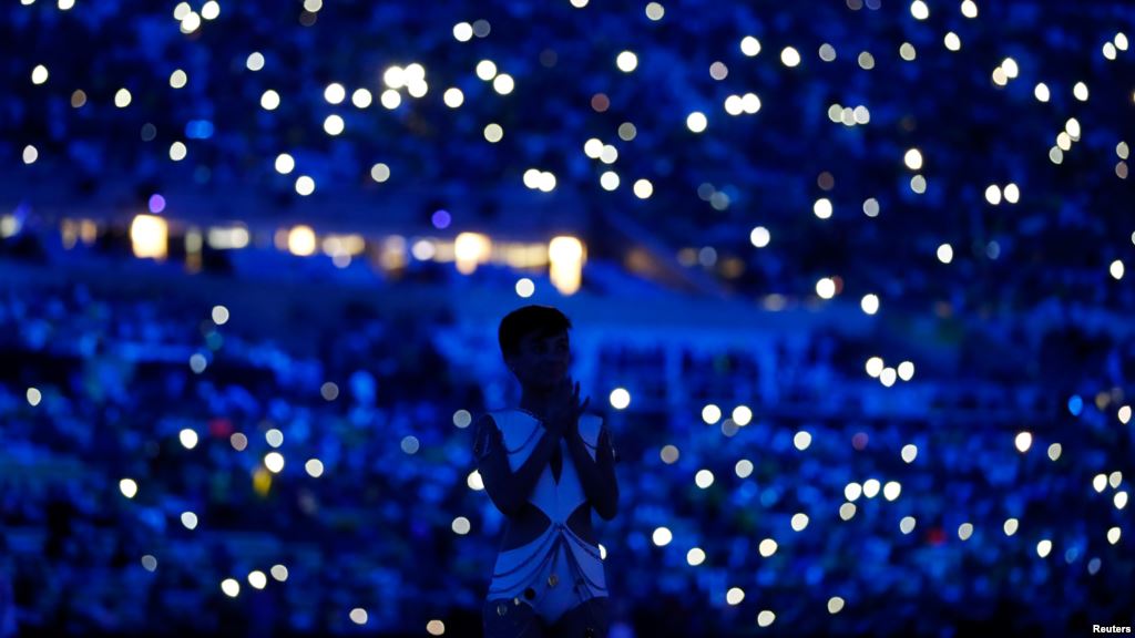 Spectators use their mobile phones for illumination during pre-show of opening ceremony in Rio de Janeiro Brazil. Aug. 5 2016