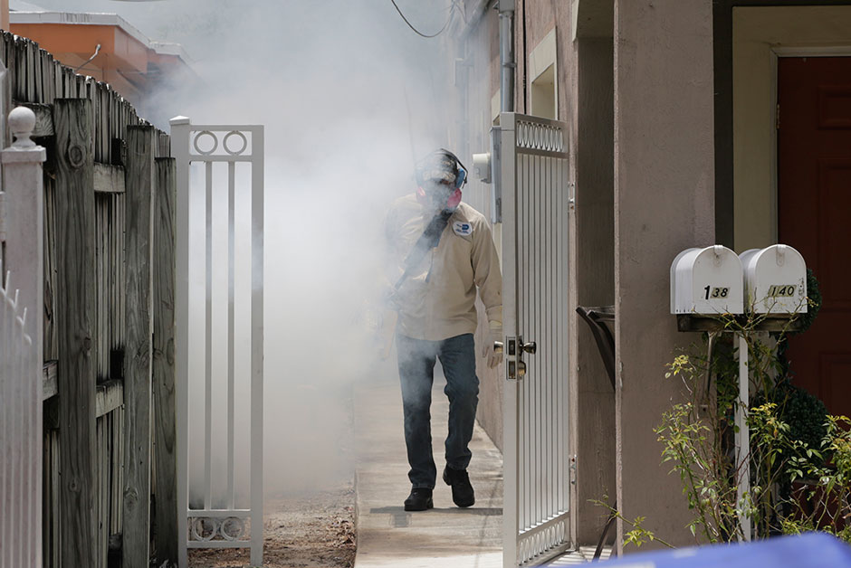 A Miami Dade County mosquito control worker sprays around a home in the Wynwood area of Miami on Aug. 1 2016. As Florida has its first reported case of Zika virus transmitted by mosquitoes on the U.S. mainland here's what Canadians need to know