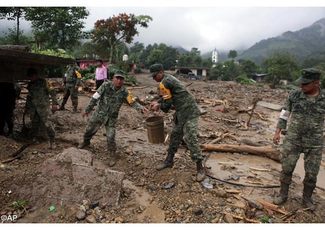 Soldiers remove mud and debris from the remains of a house destroyed by a mudslide. Tropical Storm Floyd struck Mexico on Sunday causing landslides that destroyed numerous villages and dozens of deaths.- AP