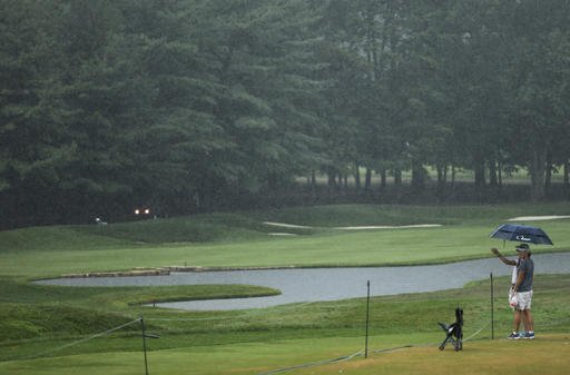 A couple look over the 18th fairway during a weather delay in the third round of the PGA Championship golf tournament at Baltusrol Golf Club in Springfield N.J. Saturday