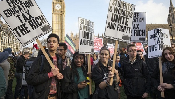 Demonstrators stand in Parliament Square in front of the Houses of Parliament during a protest against student loans and in favour of free education in central London