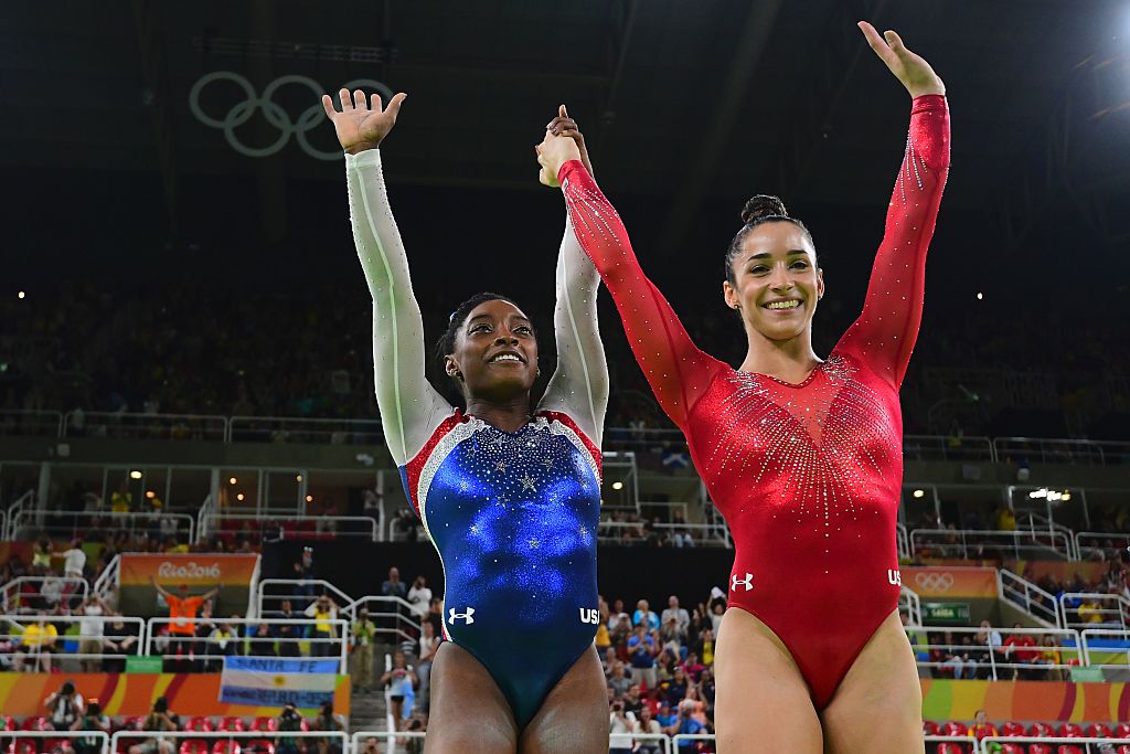 US gymnast Simone Biles and her compatiot Alexandra Raisman celebrate after the women's individual all-around final of the Artistic Gymnastics at the Olympic Arena during the Rio 2016 Olympic Games in Rio de Janeiro