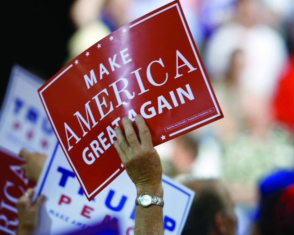 Supporters wave signs as US Republican Presidential candidate Donald Trump speaks at The Summit Sports and Ice Complex in Diamondale Michigan