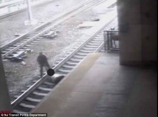 Surveillance footage shows Officer Victor Ortiz  trying to pull the man lying on the Secaucus Junction tracks Friday