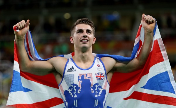 Max Whitlock celebrates winning a gold medal with the British flag