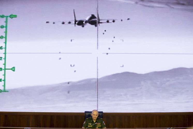 Lt.-Gen. Sergei Rudskoi of the Russian Military General Staff speaks to reporters Wednesday at a Russian Defense Ministry building in Moscow as a screen behind him shows a video released by the Russian Defense Ministry showing a Russian warplane unloading