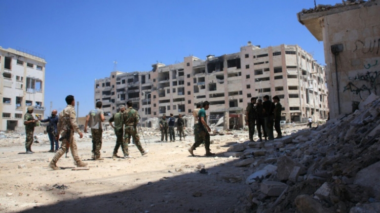 Syrian army soldiers patrol the area around the entrance of Bani Zeid after taking control of the previously rebel-held district of Leramun on the northwest outskirts of Aleppo