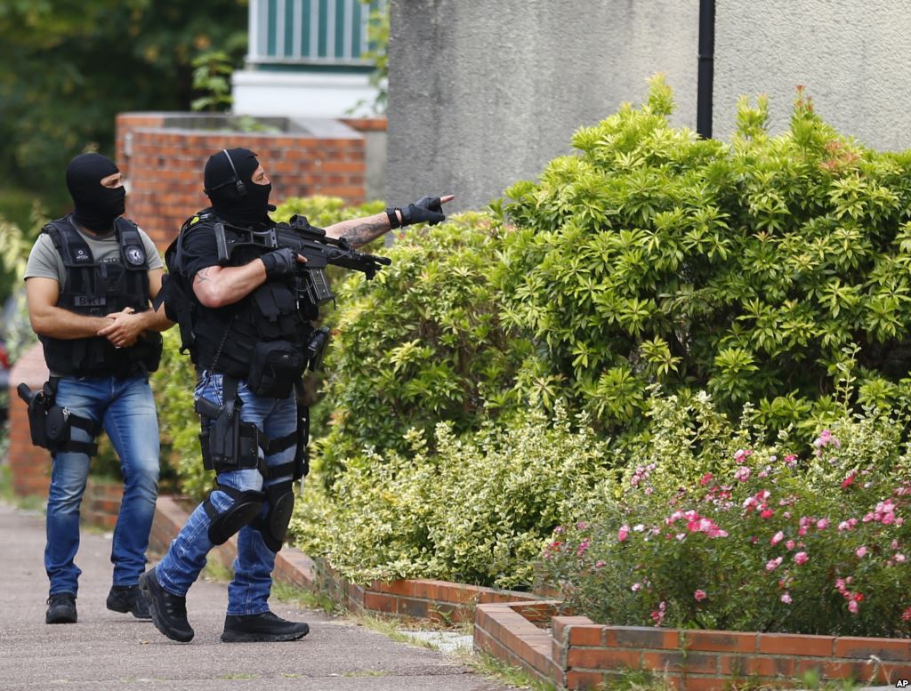 Hooded police officers conduct a search in Saint-Etienne-du-Rouvray Normandy France following an attack on a church that left a priest dead